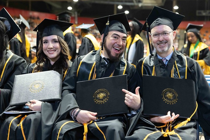 HCC students smile after receiving diplomas at a recent graduation.