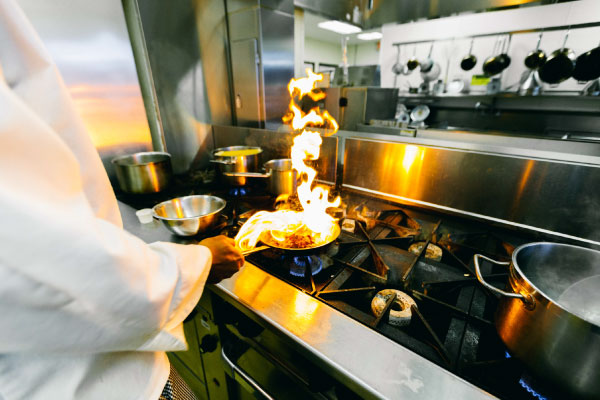 Chef cooking with a flame erupting in his pan