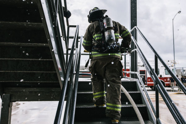 Firefighter student running up some stairs during a simulation drill