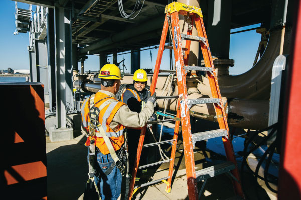 Construction workers climbing a ladder